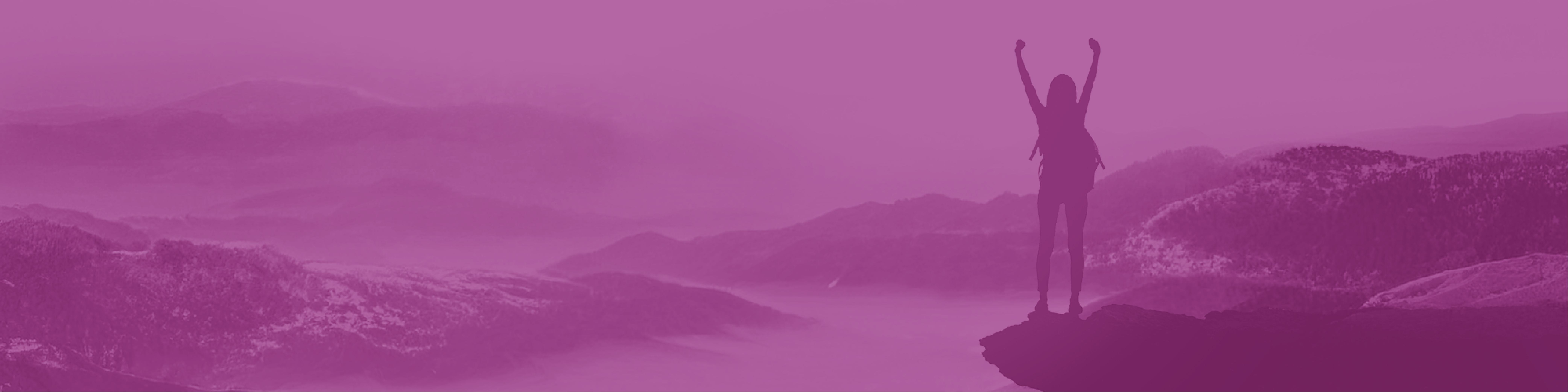 Woman standing on a mounting with her arms raised in triumph